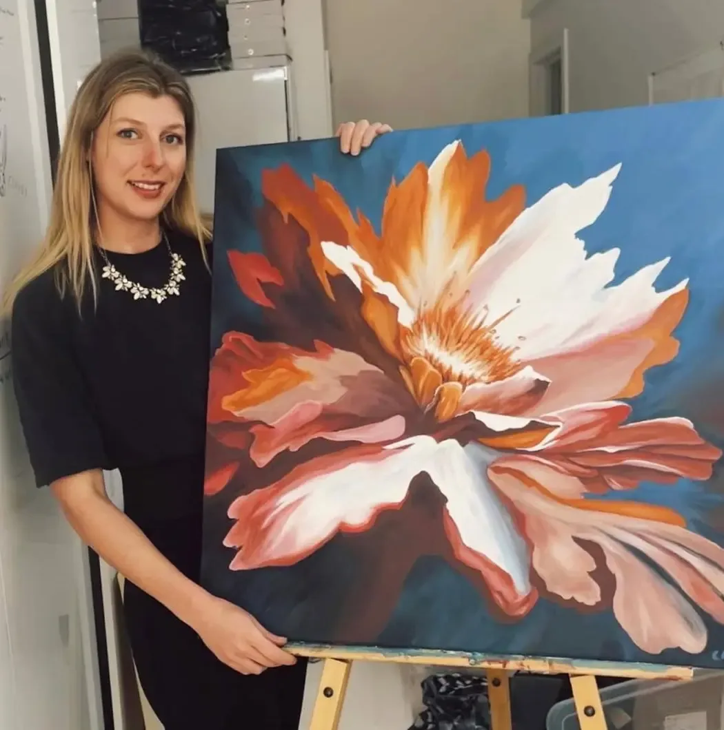 Chelsea Klukas, Seattle-based contemporary painter, standing with floral artwork